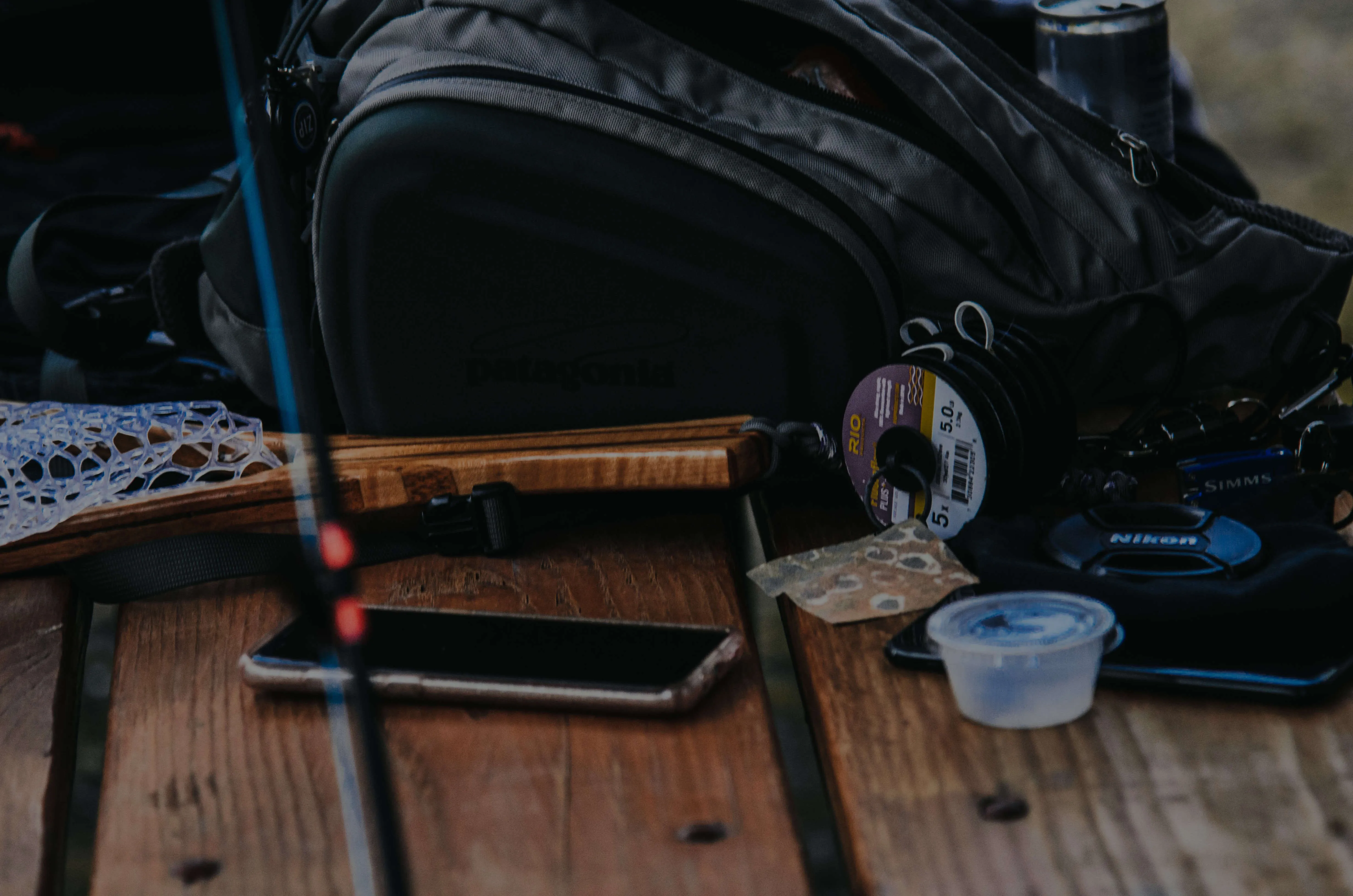 Fly fishing gear laid out on a wooden table
